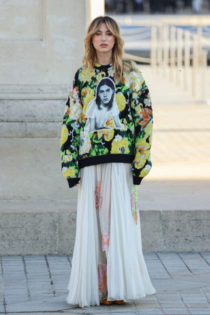 Eve Jobs en pull à motif fleurs et jupe blanche