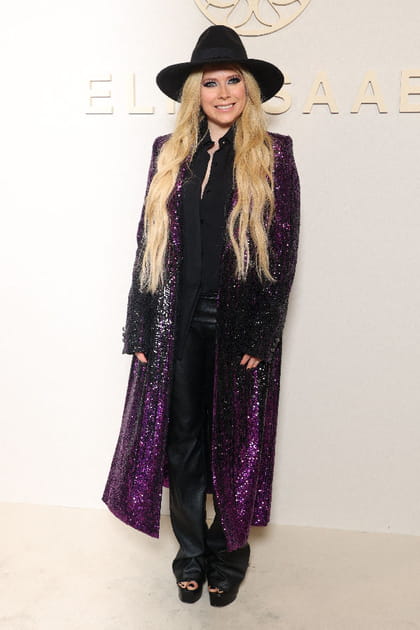 Avril Lavigne en pantalon en cuir, long manteau &agrave; sequins violets et chapeau en feutre