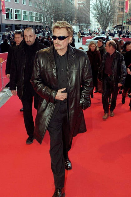Johnny Hallyday en ensemble noir et veste longue en cuir