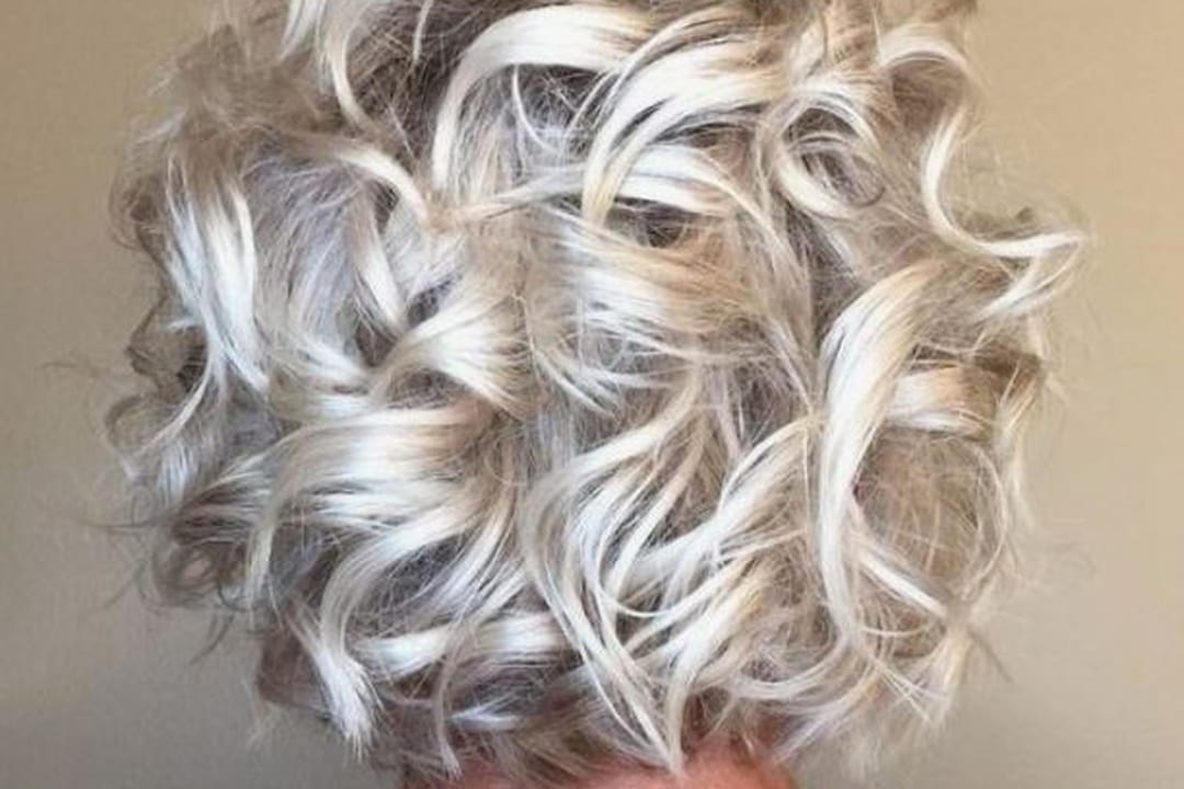 Balayage blond polaire et coupe courte bouclée