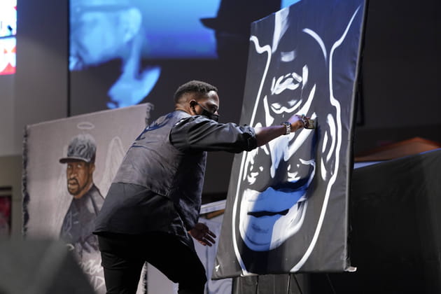 Un artiste peint devant les invités un portrait de George Floyd à l'envers