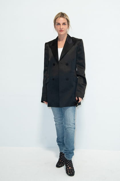 Gaia Repossi en veste de costume noire satinée et jean droit au défilé Givenchy