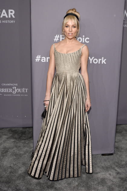 Sienna Miller en robe dorée plissée
