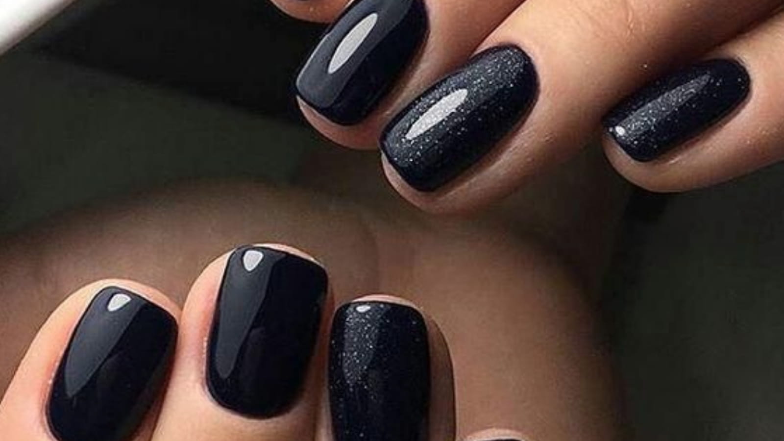 Une manucure noire avec un effet irisé
