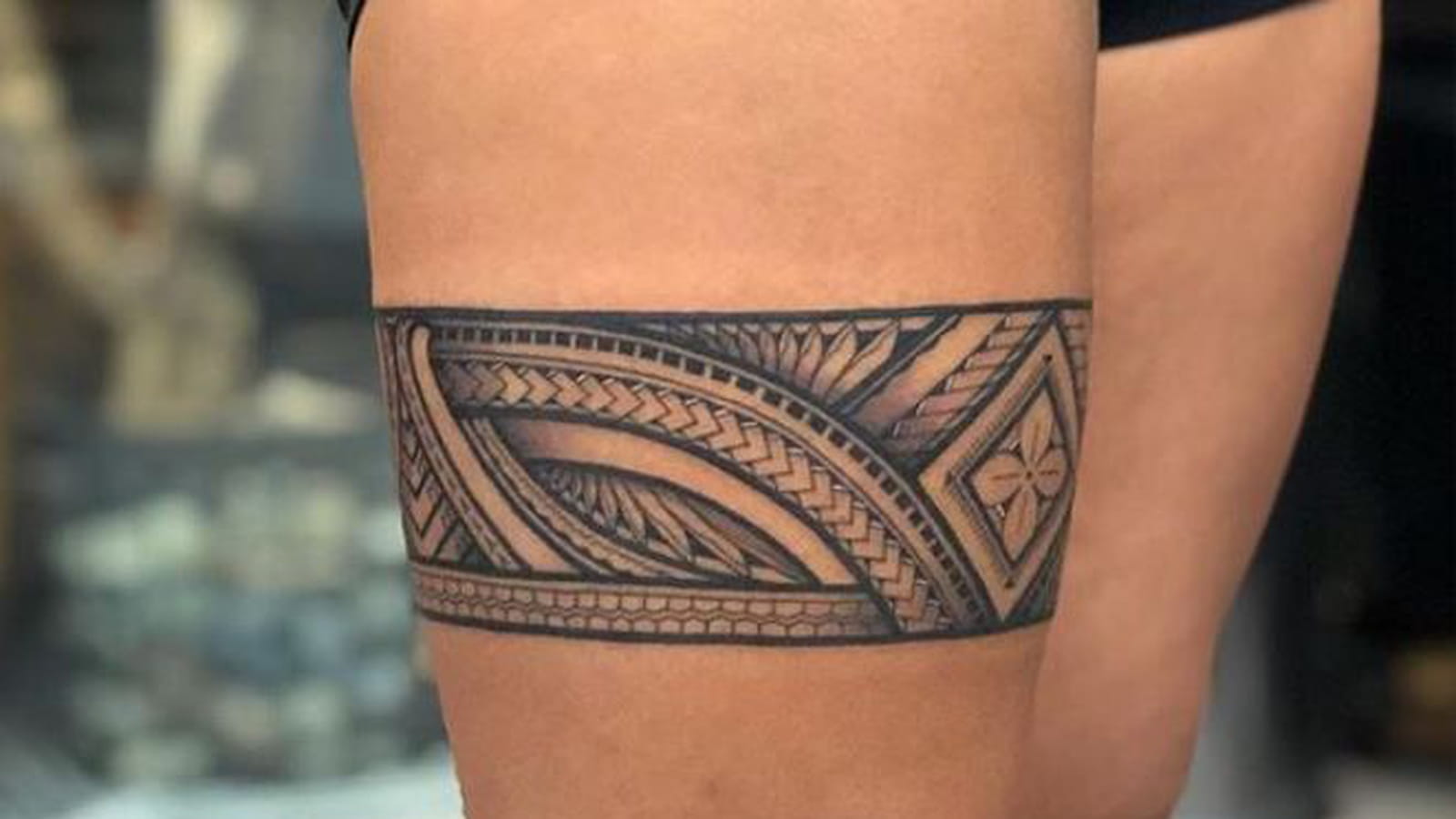 Tatouage tribal autour de la cuisse