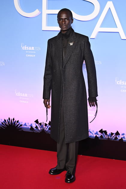 Malick Bodian en manteau long et costume noir Dior
