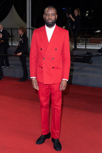 Ladj Ly en costume crois&eacute; rouge