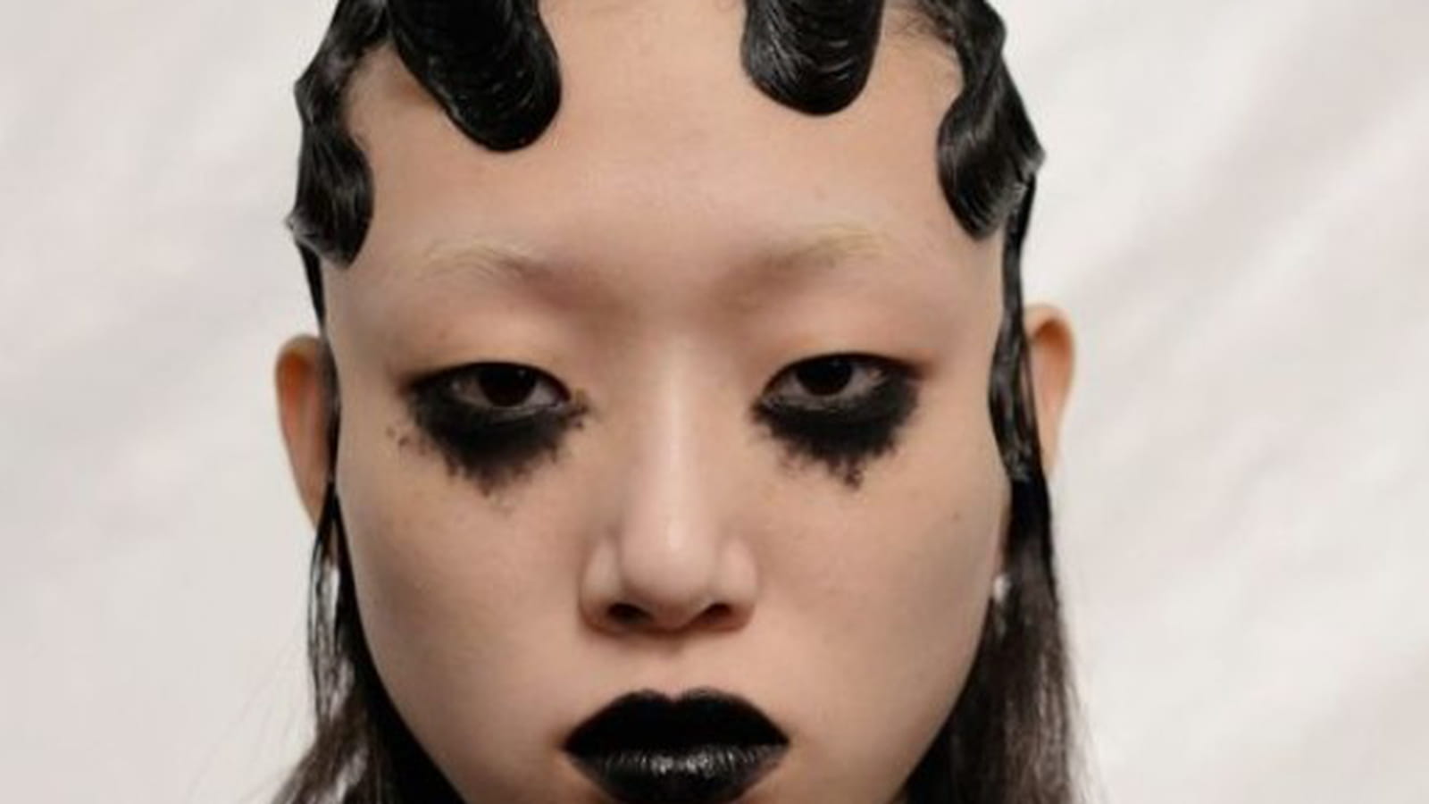 Maquillage gothique avec ras-de-cils noir et sourcils invisibles