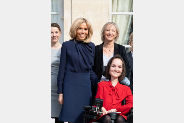 Brigitte Macron en blouse marine col drapé et jupe