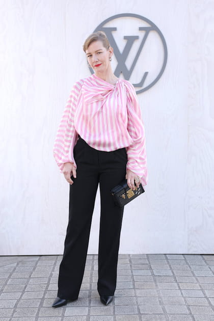 Sandra Hüller en blouse à rayures blanches et roses et pantalon noir