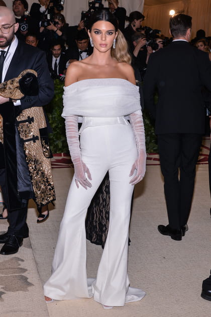 Kendall Jenner en top &agrave; encolure Bardot, pantalon flare et gants blancs