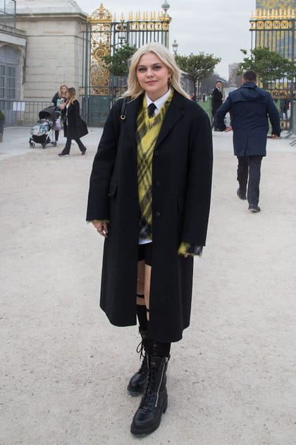 Louane en manteau noir, cravate et pull sans manches jaune &agrave; carreaux