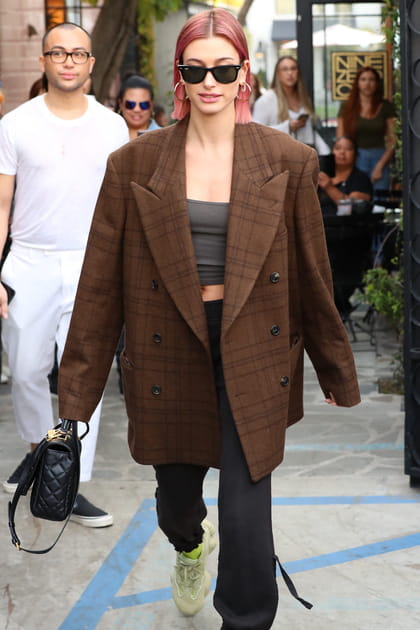 Hailey Bieber en blazer oversize, crop top et baskets