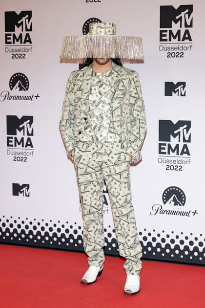 Riccardo Simonetti dans un costume en motif dollar avec un chapeau &agrave; franges