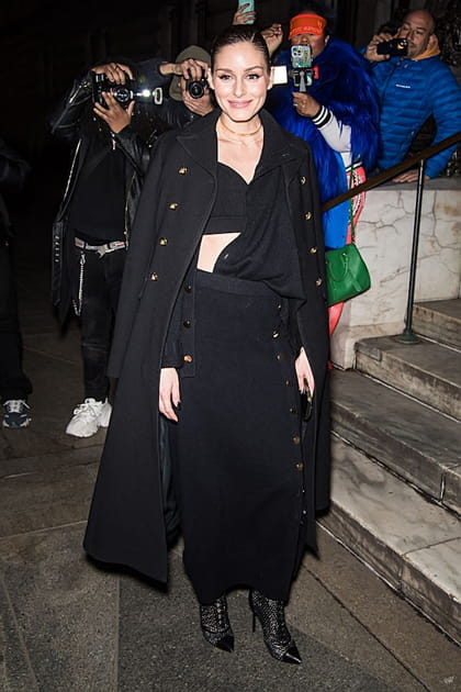 Olivia Palermo en manteau en laine noir et bottes à talons aiguilles pailletés au défilé Altuzarra