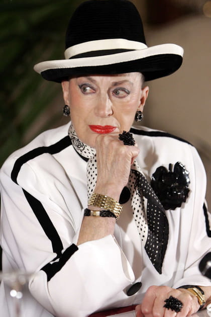 Geneviève de Fontenay en chapeau bicolore, veste blanche et foulard à pois