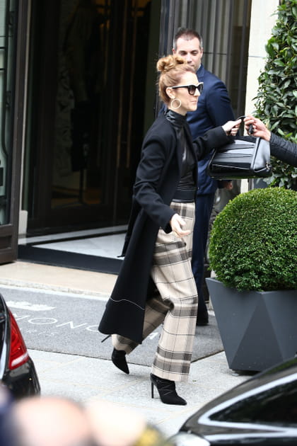 Céline Dion en pantalon blanc à carreaux et manteau noir