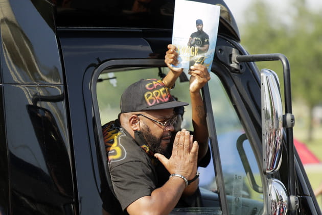 Un manifestant joint ses mains à l'extérieur de son véhicule en hommage à George Floyd