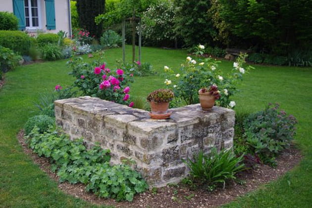 Un muret et des plantes pour cacher un puisard