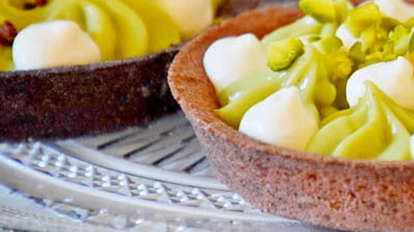 Tartelette garnie de crème pâtissière à la pistache sur un lit de caramel au beurre salé