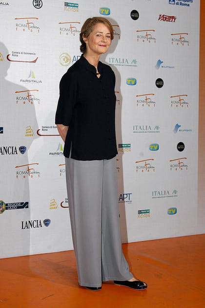 Charlotte Rampling en pantalon gris fluide et chemise noire