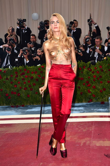 Cara Delevingne en bustier doré et pantalon rouge