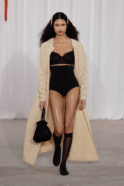 Sous-v&ecirc;tements noirs et long trench camel aper&ccedil;us lors du d&eacute;fil&eacute; Meruert Tolegen