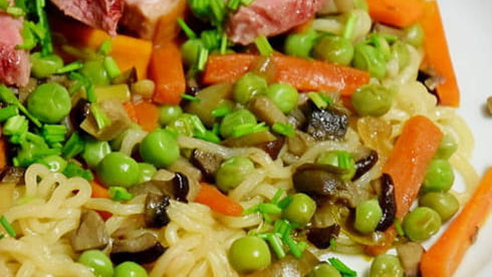 Filet de canard sur un lit de nouilles sautées et ses petits légumes