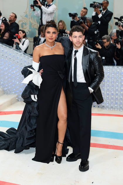 Priyanka Chopra Jonas en robe bustier noire fendue Valentino et Nick Jonas en veste en cuir et pantalon Valentino