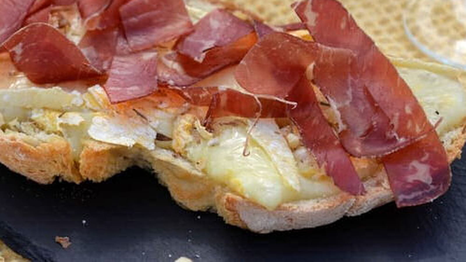 Bruschetta au Reblochon, huile citronnée, noix et jambon