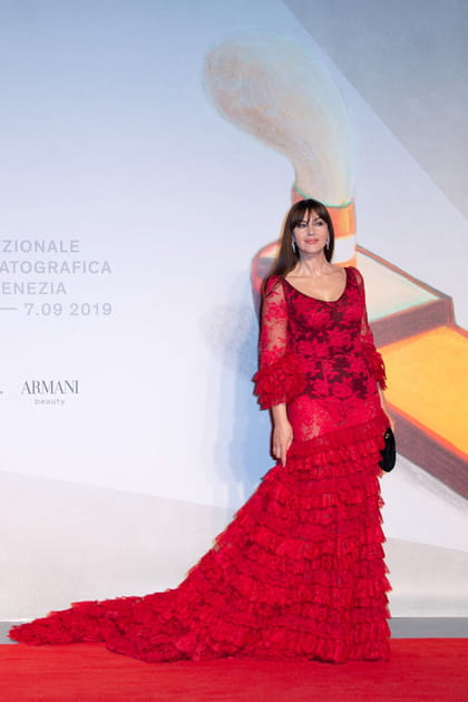 Monica Bellucci en robe rouge en dentelle transparente Dolce & Gabbana et bijoux Cartier