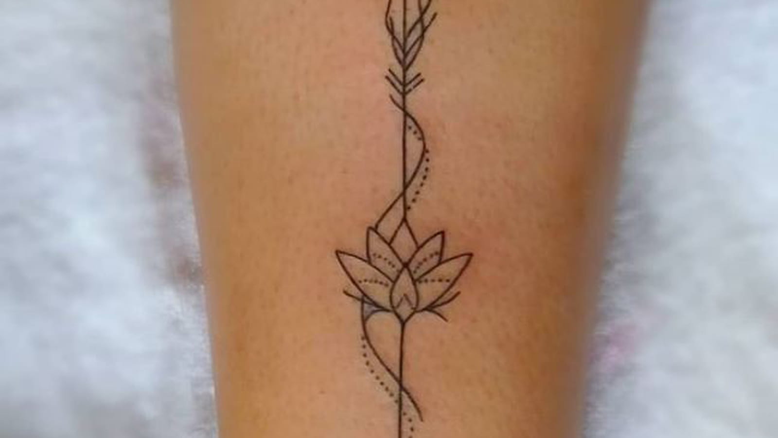 Flèche et fleur de lotus sur la jambe