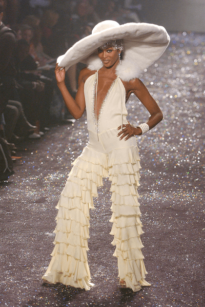 Naomi Campbell en combinaison blanche &agrave; volants et chapeau XXL