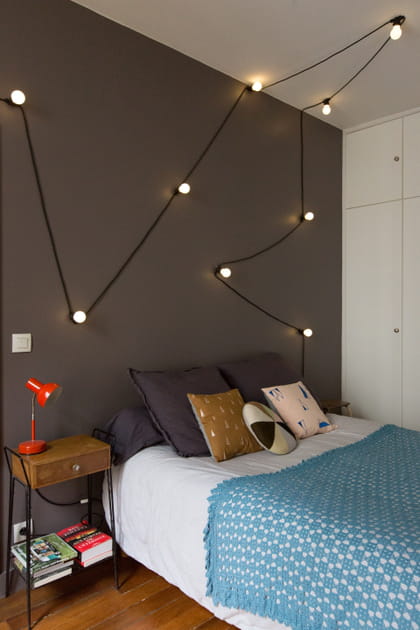 Une guirlande d'ampoules en guise de tête de lit