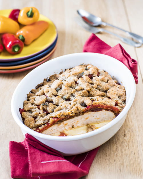Crumble de noisettes et de parmesan, filets de poulet Père Dodu aux poivrons aillés et aux tomates confites