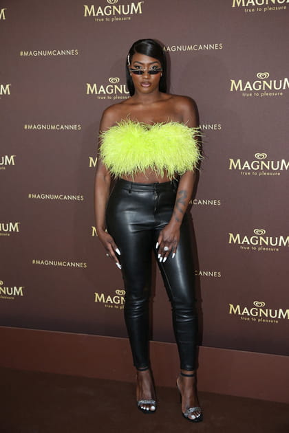 Aya Nakamura en bandeau jaune à plumes et pantalon slim en cuir