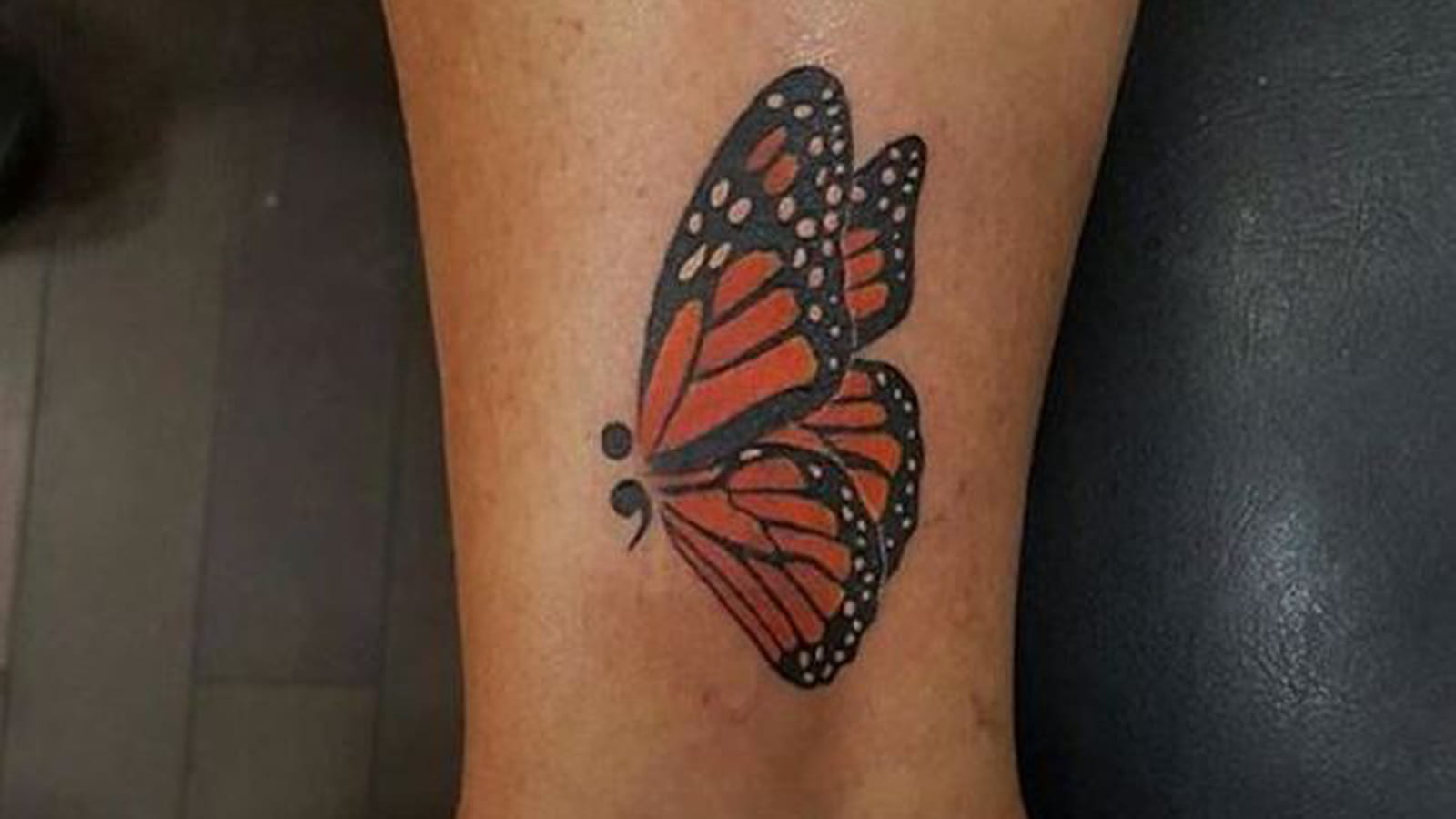 Point-virgule et papillon sur la cheville
