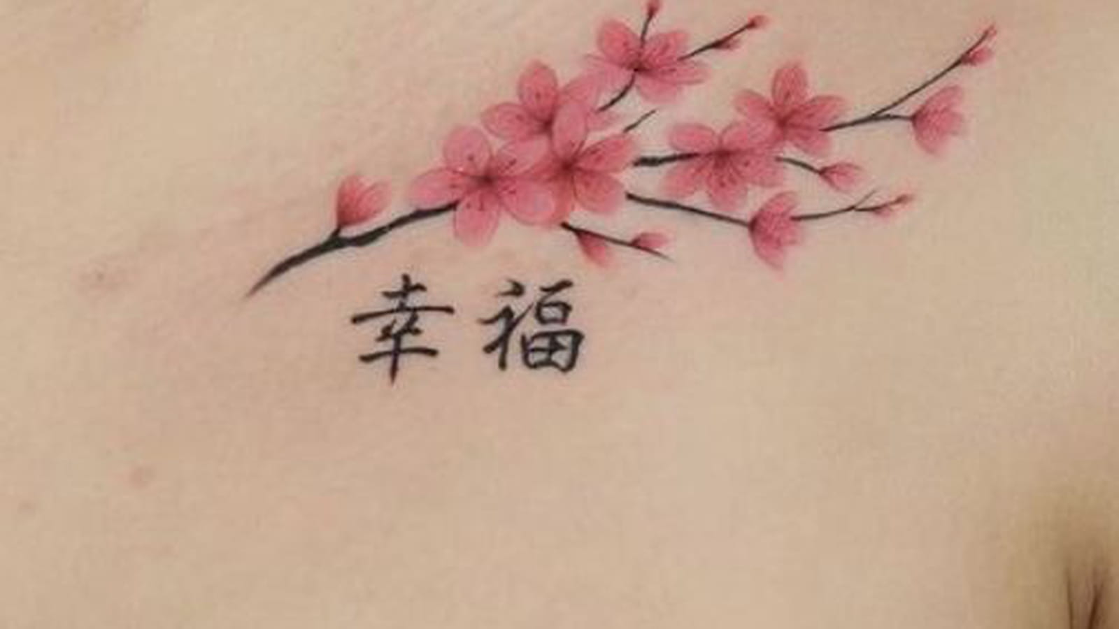 Fleurs de cerisier et symboles chinois sous la clavicule