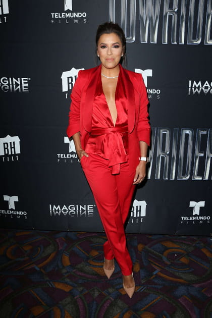 Eva Longoria en combinaison rouge satinée au décolleté plongeant à nœud