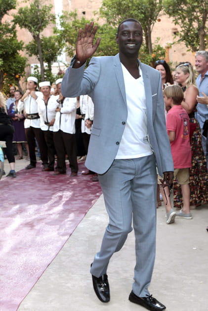 Omar Sy en costume gris clair et T-shirt blanc