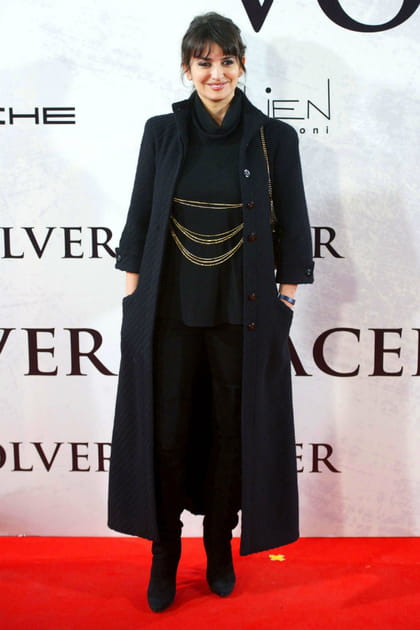 Pen&eacute;lope Cruz en manteau long noir et ceinture &agrave; cha&icirc;nes dor&eacute;es
