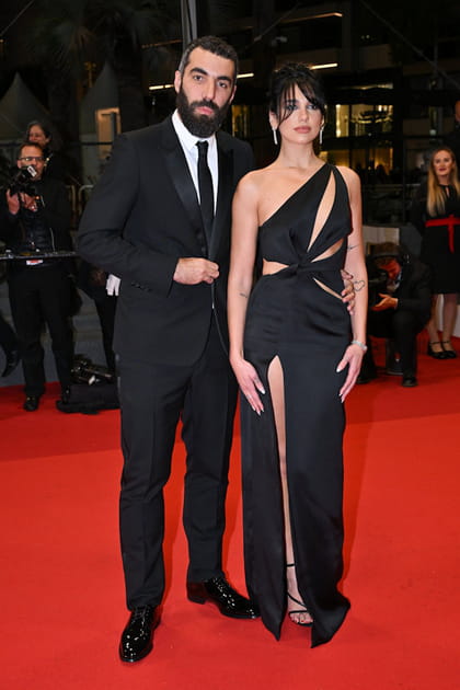 Romain Gavras en costume noir Dior et Dua Lipa en robe cut out