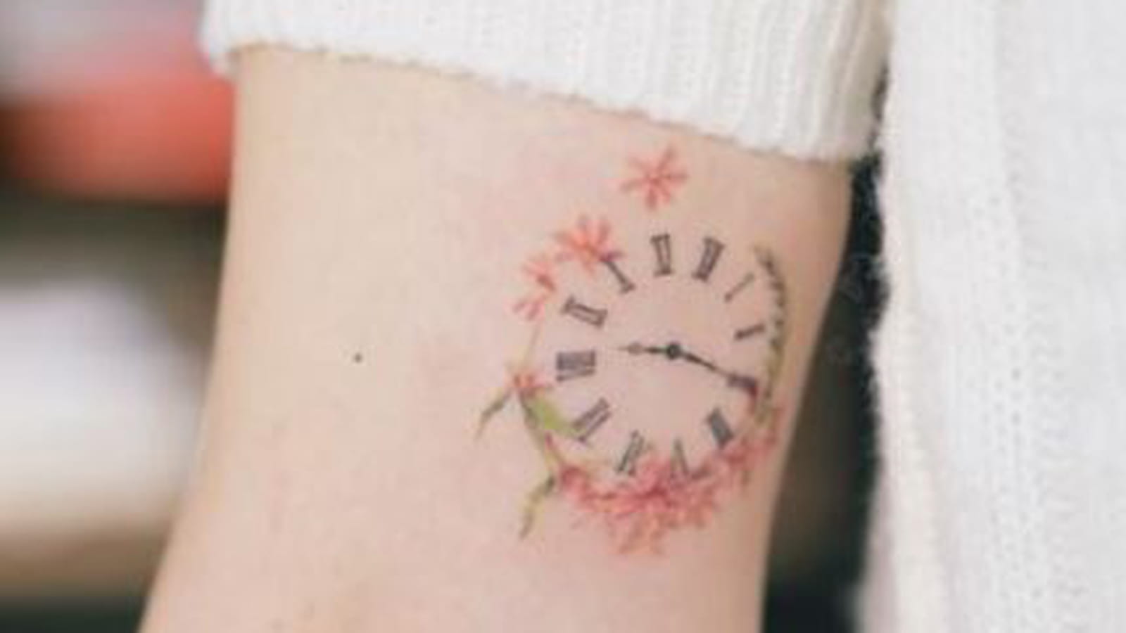 Horloge et couronne fleurie sur le bras