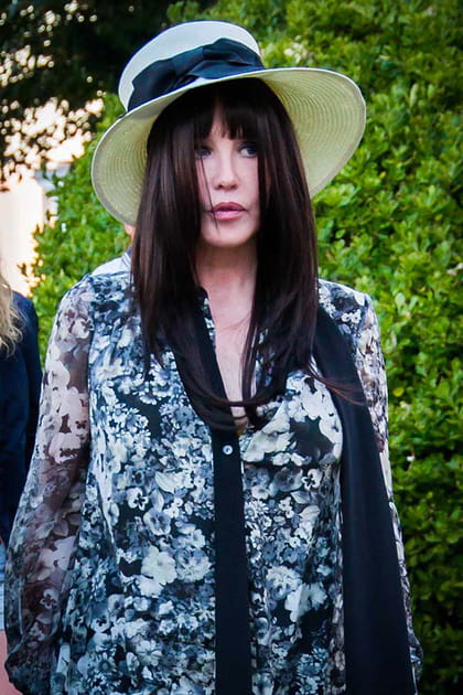 Isabelle Adjani en robe fluide à motifs et chapeau en paille