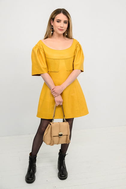 Emma Roberts en petite robe jaune rigide à détails et bottines en cuir au défilé Givenchy