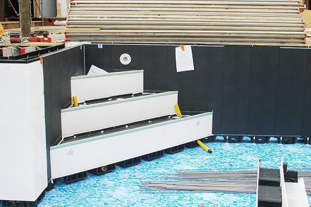 Une piscine hors sol avec 2 escaliers
