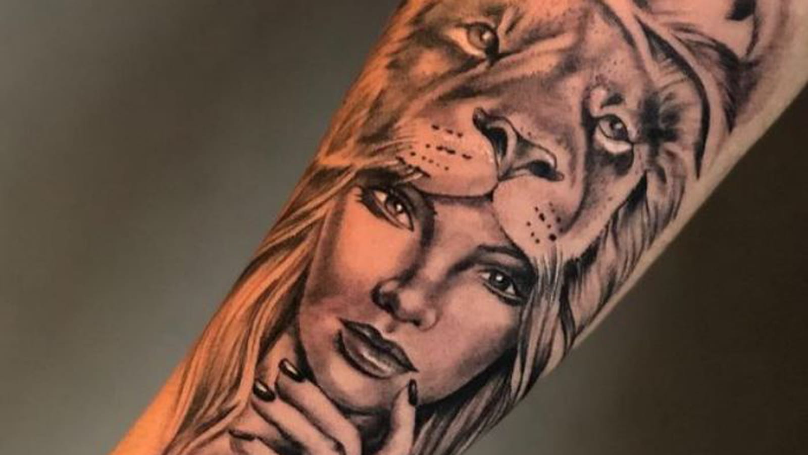 Lion et visage féminin sur le bras