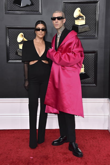 Kourtney Kardashian en combinaison noire et Travis Barker en costume