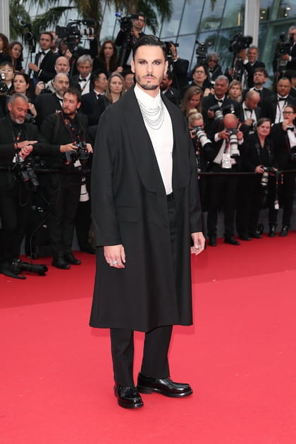 Baptiste Giabiconi en manteau noir, chemise blanche et pantalon droit Dior