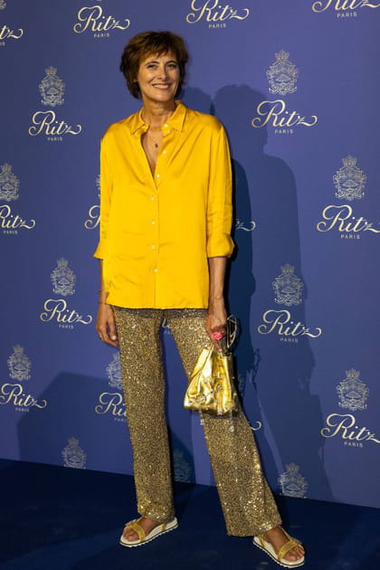 Inès de la Fressange en chemise satinée jaune et pantalon brodé de sequins